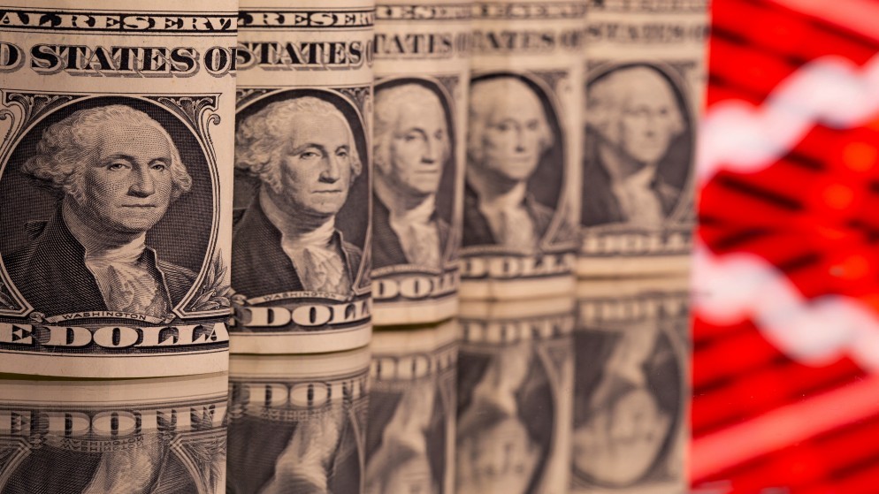 أوراق نقدية بالدولار الأميركي أمام الرسم البياني للأسهم المعروض في هذا الرسم التوضيحي.8 فبراير 2021. (رويترز )