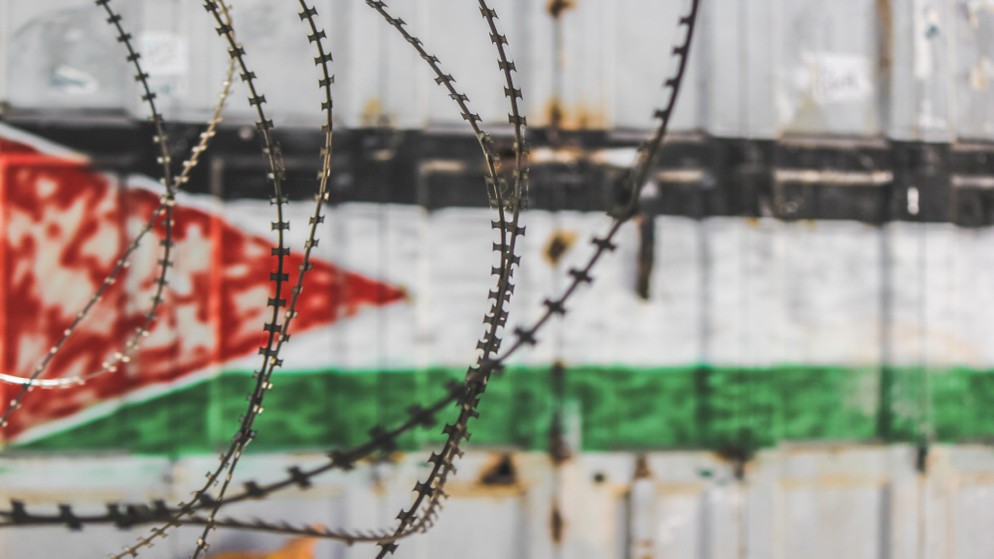 علم فلسطين من خلال الأسلاك الشائكة في مدينة الخليل القديمة. (shutterstock)