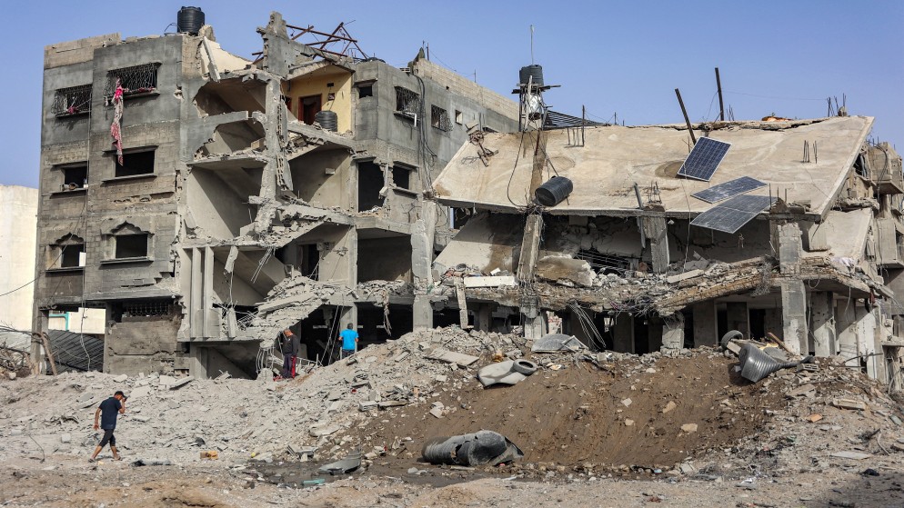 فلسطينيون يتفقدون حطام مبنى انهار جزئيا بسبب القصف الإسرائيلي في مدينة غزة .18 نيسان 2024. (أ ف ب)