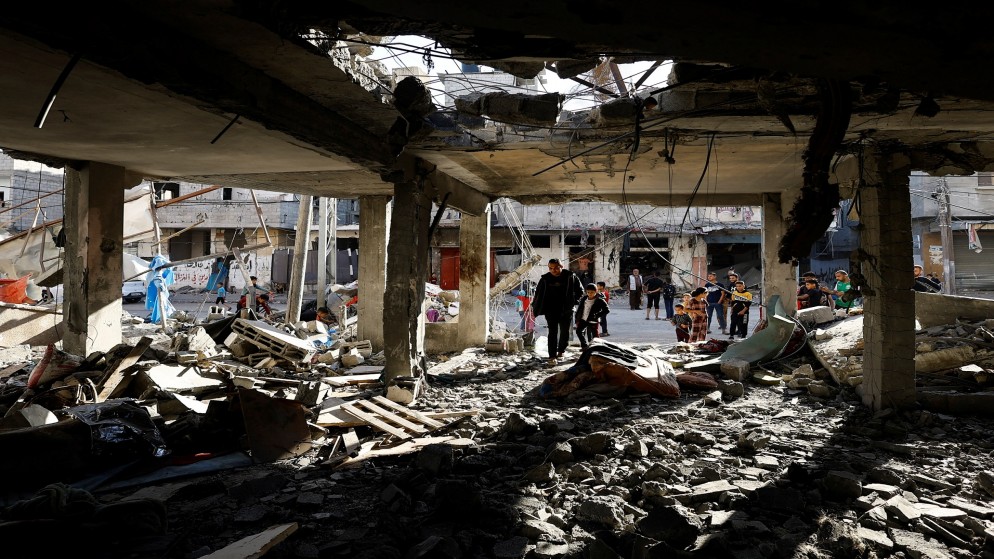 فلسطينيون يتفقدون موقع غارة من الاحتلال الإسرائيلي على منزل، في رفح جنوبي قطاع غزة، 17 نيسان 2024. (رويترز)
