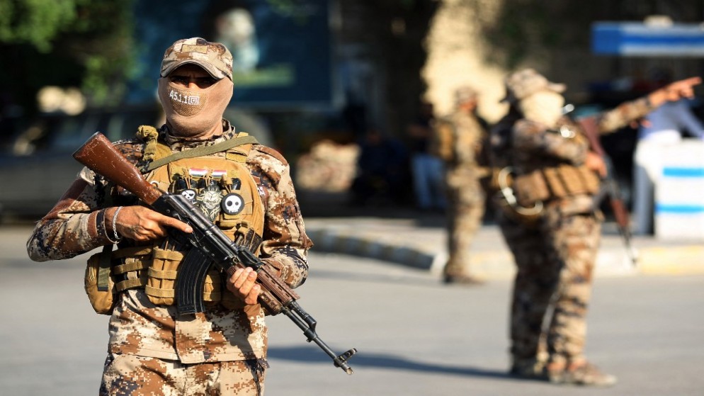 عناصر من قوات الحشد الشعبي، يحرسون موكبا جنائزيا في العاصمة العراقية بغداد، 26 تشرين الأول 2019، (أ ف ب)