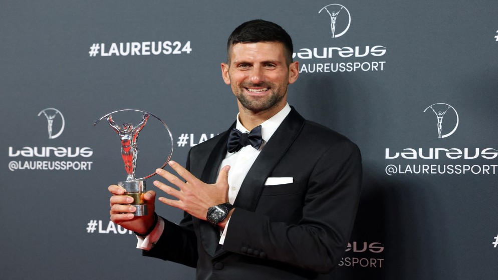 الصربي نوفاك ديوكوفيتش المصنف أول عالميا في كرة المضرب مع جائزة رياضي العام ضمن جوائز لوريوس. (رويترز)