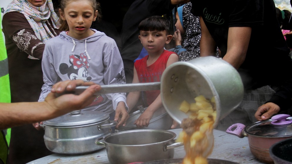 متطوعون يسلمون الطعام للعائلات في جباليا بشمال قطاع غزة، 22 نيسان 2024. (رويترز)