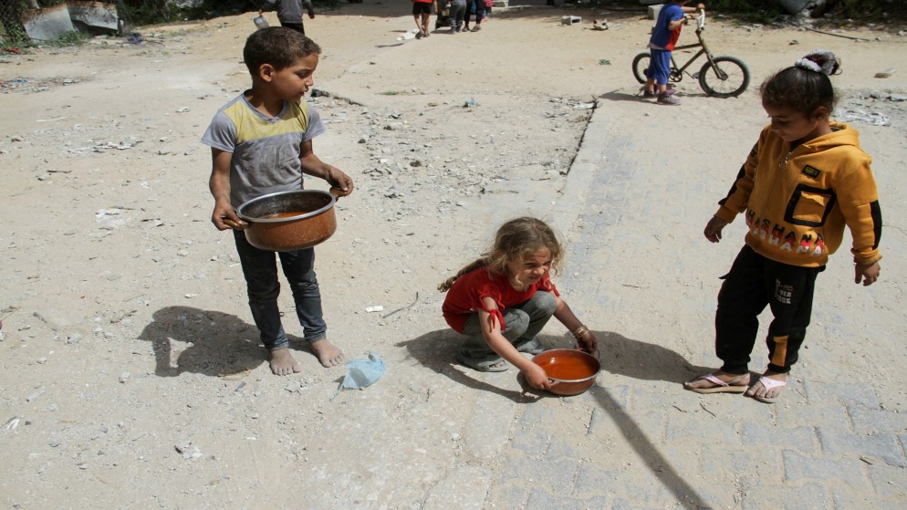 أطفال يحملون أواني طعام في جباليا بشمال قطاع غزة، 22 نيسان 2024. (رويترز)