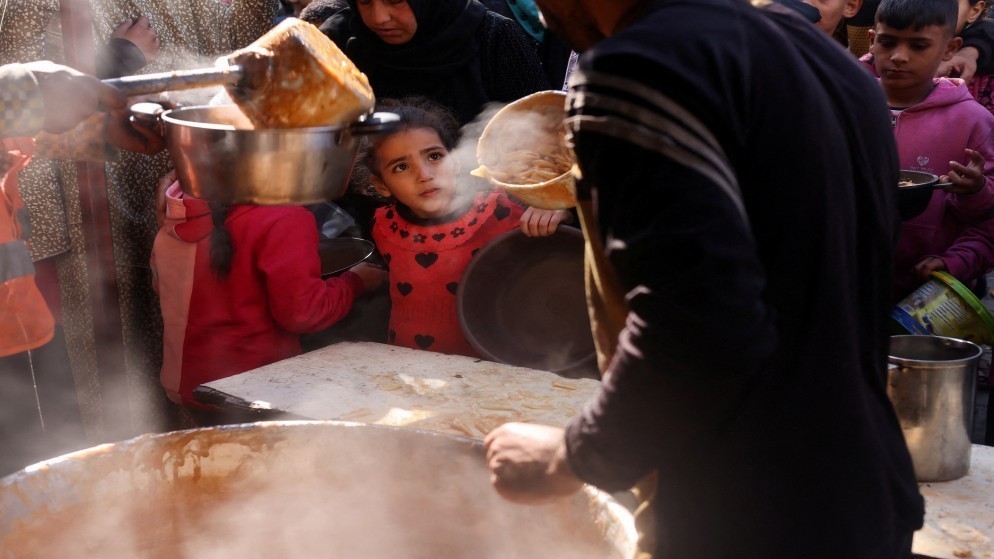 فلسطينيون ينتظرون الحصول على الطعام في رفح جنوبي قطاع غزة، 16 يناير 2024. (رويترز)