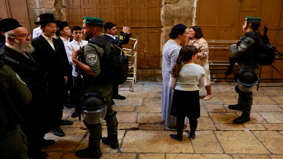 عناصر في شرطة الاحتلال الإسرائيلي وإلى جانبهم مستوطنون متطرفون. (رويترز)