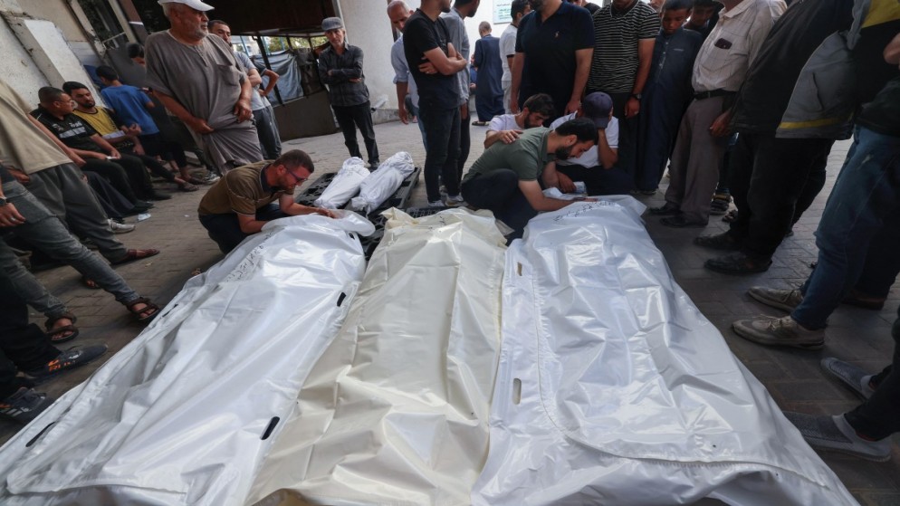 فلسطينيون بالقرب من جثامين شهداء في مستشفى النجار في مدينة رفح جنوبي قطاع غزة جراء القصف الإسرائيلي. 25 أبريل 2024. (أ ف ب)
