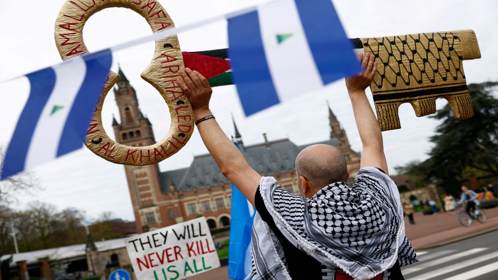 متظاهر داعم الفلسطينيين قرب أعلام نيكاراغوا، خارج قصر السلام في لاهاي الذي يضم محكمة العدل الدولية، 8 نيسان/أبريل 2024. (رويترز)