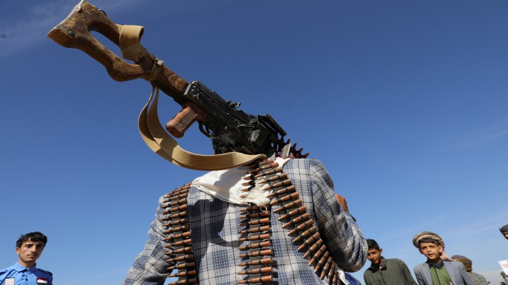 رجل موالٍ للحوثيين يحمل سلاحا خلال استعراض عسكري في اليمن. (رويترز)