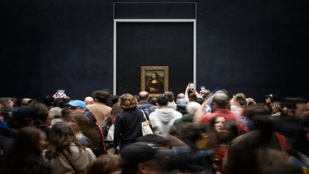 زوار يلتقطون صورة للوحة "موناليزا" للفنان الإيطالي ليوناردو دافنشي المعروضة في متحف اللوفر في باريس، 20 نيسان/أبريل 2023. (أ ف ب)