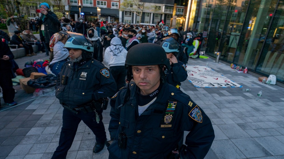 ضباط شرطة يسيرون وسط الطلاب والمؤيدين للفلسطينيين الذين احتلوا ساحة في حرم جامعة نيويورك، في مدينة نيويورك، الولايات المتحدة، 26 أبريل 2024. (رويترز)