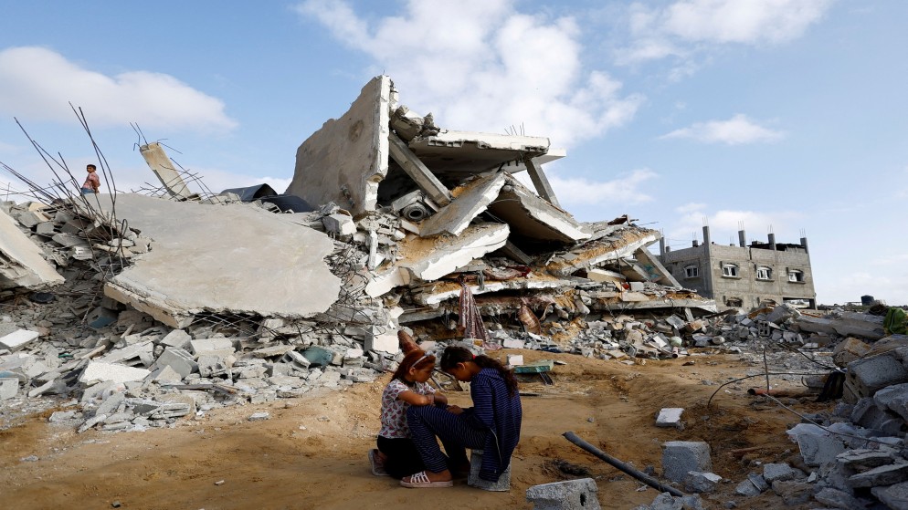 طفلان فلسطينيان بجوار دمار إثر قصف إسرائيلي في رفح بجنوب قطاع غزة، 21 نيسان/ أبريل 2024. (رويترز)