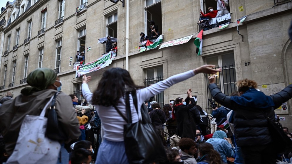 متظاهرون بالقرب من مدخل مبنى في باريس، 26 نيسان 2024. (أ ف ب)