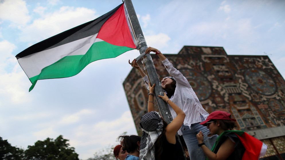 طلاب يعلقون العلم الفلسطيني، خلال احتجاج في الحرم الجامعي في جامعة المكسيك لدعم الفلسطينيين، في مكسيكو سيتي، المكسيك. 2 مايو 2024. (رويترز)