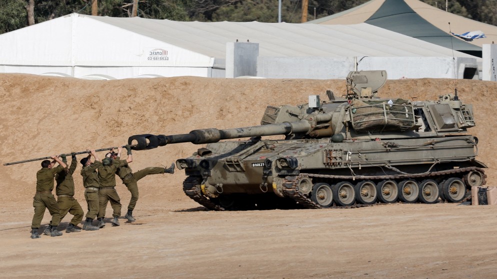 جنود إسرائيليون يقومون بتنظيف فوهة مدفعية بالقرب من الحدود مع قطاع غزة، 30 نيسان/ أبريل 2024. (رويترز)