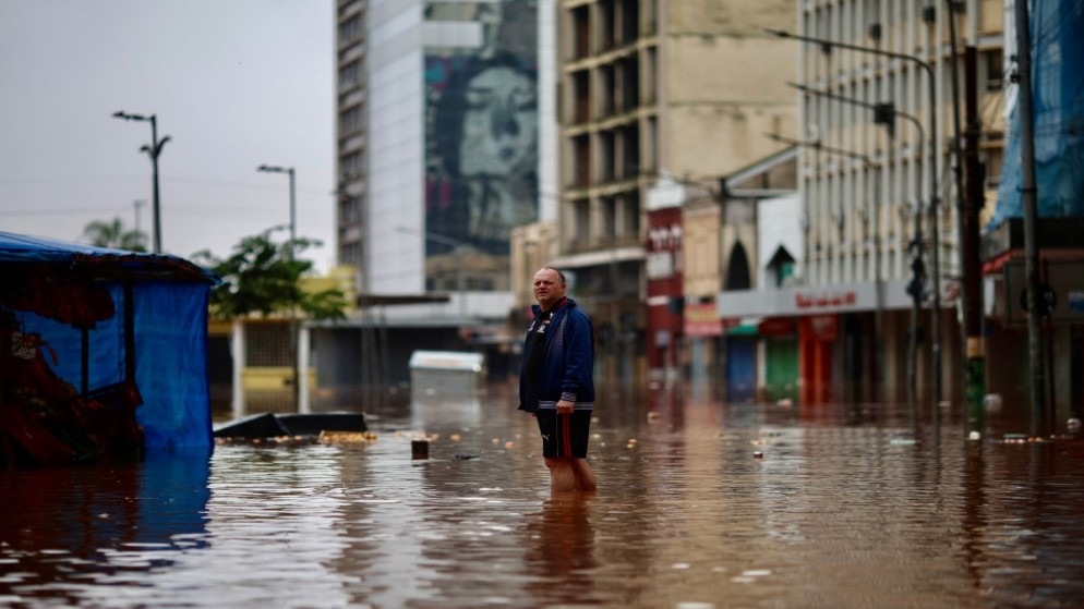 رجل يقف في شارع غمرته المياه في المركز التاريخي لمدينة بورتو أليغري في البرازيل، 4 أيار/مايو 2024. (أ ف ب)
