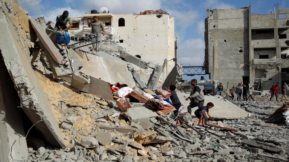 فلسطينيون يحملون ممتلكاتهم في موقع غارة إسرائيلية على منزل في رفح جنوبي قطاع غزة .5 مايو 2024.(رويترز)