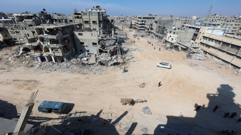 فلسطينيون بين مبان مدمر في خان يونس جنوبي قطاع غزة. (رويترز)