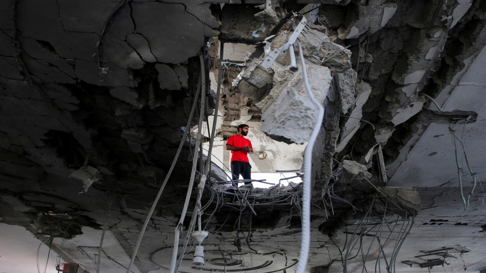 شاب فلسطيني يقف داخل مبنى تعرض لقصف إسرائيلي في رفح جنوبي قطاع غزة. (رويترز)