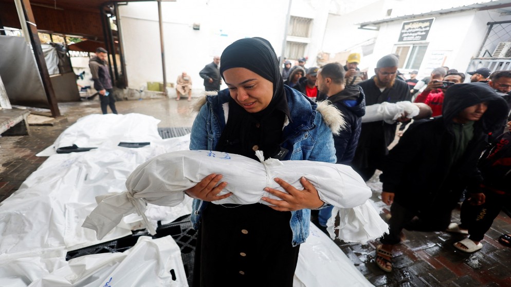 فلسطينية تحمل جثمان طفلها الذي استشهد في غارة للاحتلال الإسرائيلي على رفح جنوبي قطاع غزة. 06/05/2024. (رويترز)