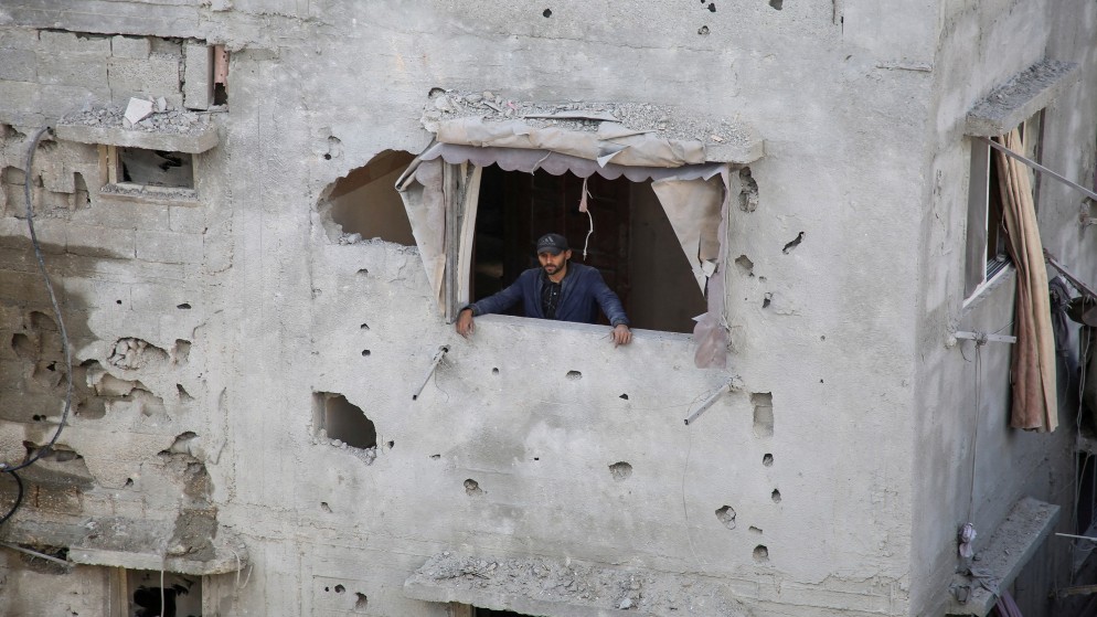 فلسطيني ينظر من نافذة منزل متضرر في رفح إثر غارة إسرائيلية، 7 أيار/ مايو 2024. (رويترز)