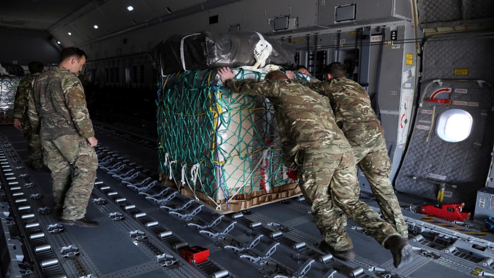أفراد عسكريون بريطانيون يقومون بتحميل طرود المساعدات على طائرة سيتم إنزالها جوا فوق غزة، 9 مايو 2024. (رويترز)