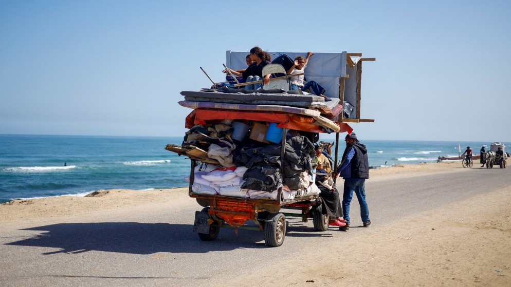 فلسطينيون يسافرون في عربة أثناء نزوحهم من رفح بعد أن شنت القوات الإسرائيلية عملية برية وجوية في الجزء الشرقي من جنوب مدينة غزة. 9 مايو، 2024. ( رويترز)