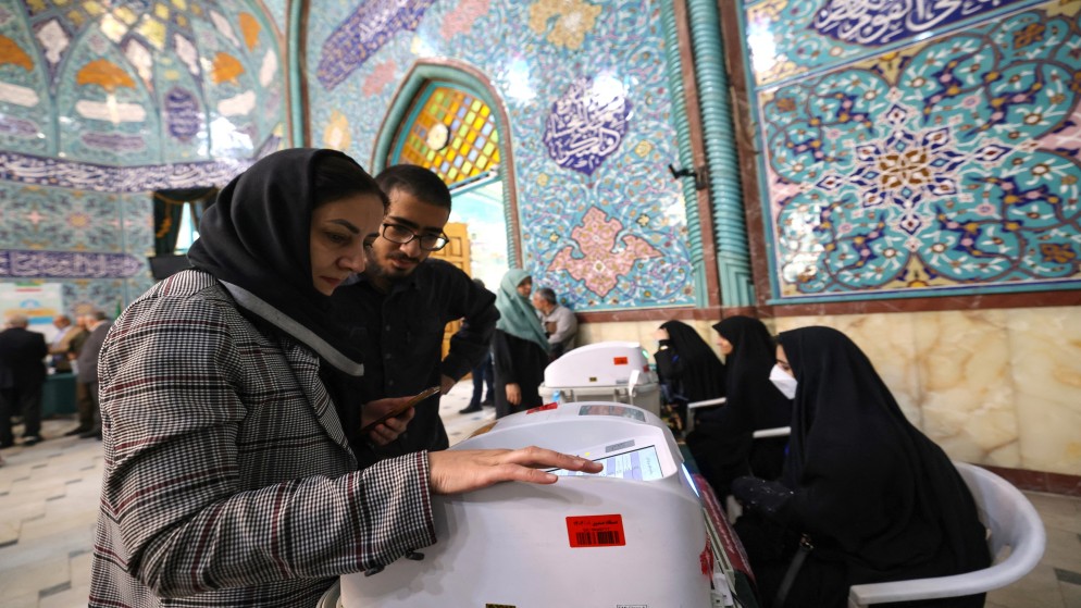 إيرانيون يدلون بأصواتهم في مركز اقتراع في طهران خلال انتخابات الإعادة البرلمانية .10 مايو 2024.(أ ف ب)