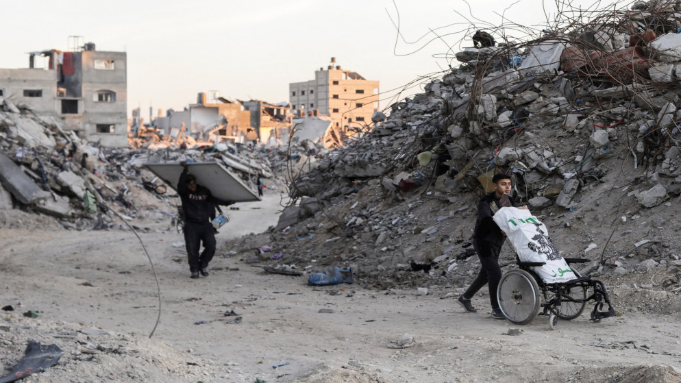 فلسطينيون يسيرون أمام منازل مدمرة، وسط وقف إطلاق النار في غزة، في مخيم جباليا للاجئين، شمالي قطاع غزة، 20 يناير 2025. (رويترز/محمود عيسى)