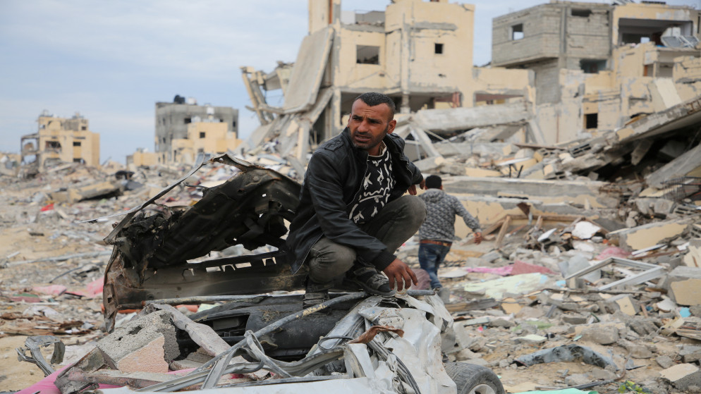 فلسطيني يلوح بيده وسط أنقاض المباني المدمرة خلال الهجوم الإسرائيلي، في أعقاب وقف إطلاق النار بين إسرائيل وحماس، في رفح في جنوب قطاع غزة، 22 يناير 2025. رويترز