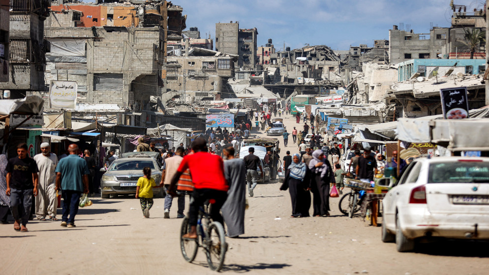 فلسطينيون يسيرون أمام المباني المتضررة على طول أحد الشوارع في خان يونس في جنوب قطاع غزة في 30 أيول 2025. (أ ف ب)