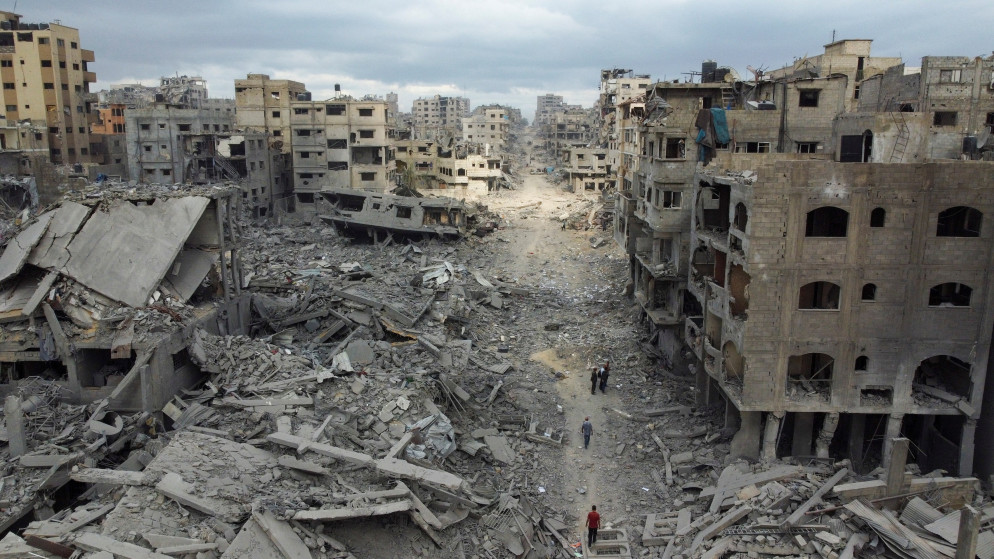 فلسطينيون يسيرون بين الأنقاض بعد انسحاب قوات الاحتلال الإسرائيلية مدينة غزة. 12 تشرين الأول 2025. (رويترز)
