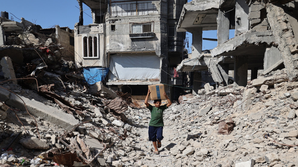 طفل فلسطيني يحمل طرد مساعدات. (أ ف ب)