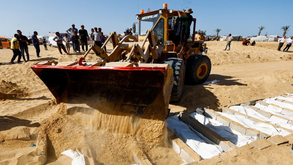المعدات الثقيلة تساعد في دفن جثث مجهولة الهوية لفلسطينيين كانوا محتجزين لدى الاحتلال أثناء الحرب. دير البلح، في وسط قطاع غزة، 22 تشرين الأول 2025. (رويترز)