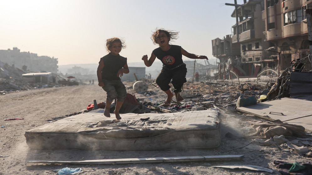 طلفتان فلسطينيتان تلهوان على أنقاض المأساة في غزة. (أ ف ب)
