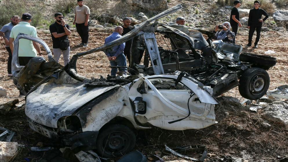 أشخاص يتفقدون حطام سيارة استهدفتها غارة إسرائيلية في قرية حاروف جنوبيّ لبنان في 25 تشرين الأول 2025. (أ ف ب)