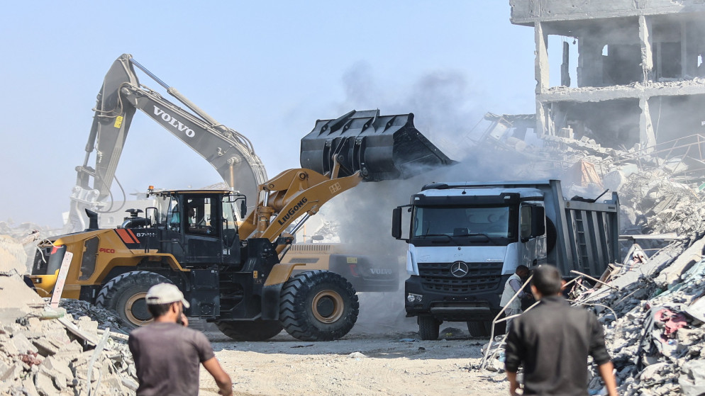 آليات تعمل على إزالة أثار الدمار في غزة. (أ ف ب)