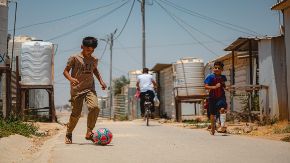 طفلان يلعبان كرة القدم في مخيم الزعتري للاجئين السوريين بمحافظة المفرق شمالي الأردن. (مفوضية اللاجئين)