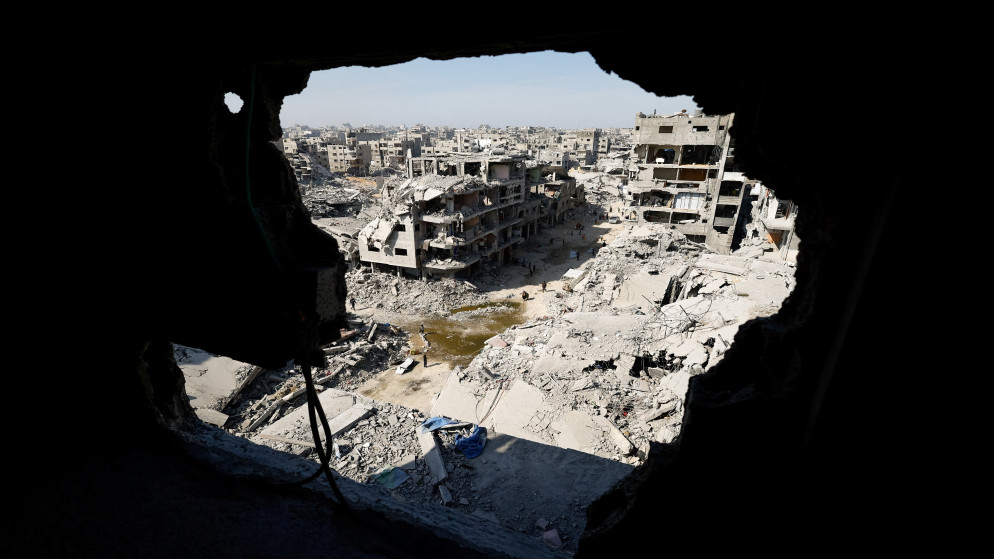 فلسطينيون يسيرون بين أنقاض المباني المدمرة في مدينة غزة. 2 تشرين الثاني 2025. (رويترز)