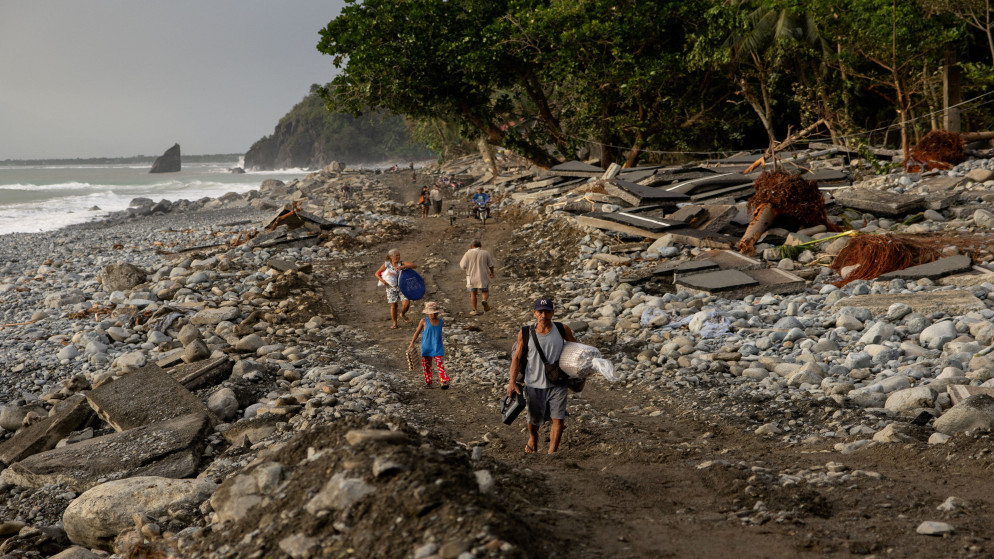 يسير السكان على طول الجزء المتضرر من طريق بالير-كاسيجوران الذي تضرر بسبب العواصف الناجمة عن إعصار فونغ وونغ، الفلبين، 11 تشرين الثاني 2025. (رويترز)