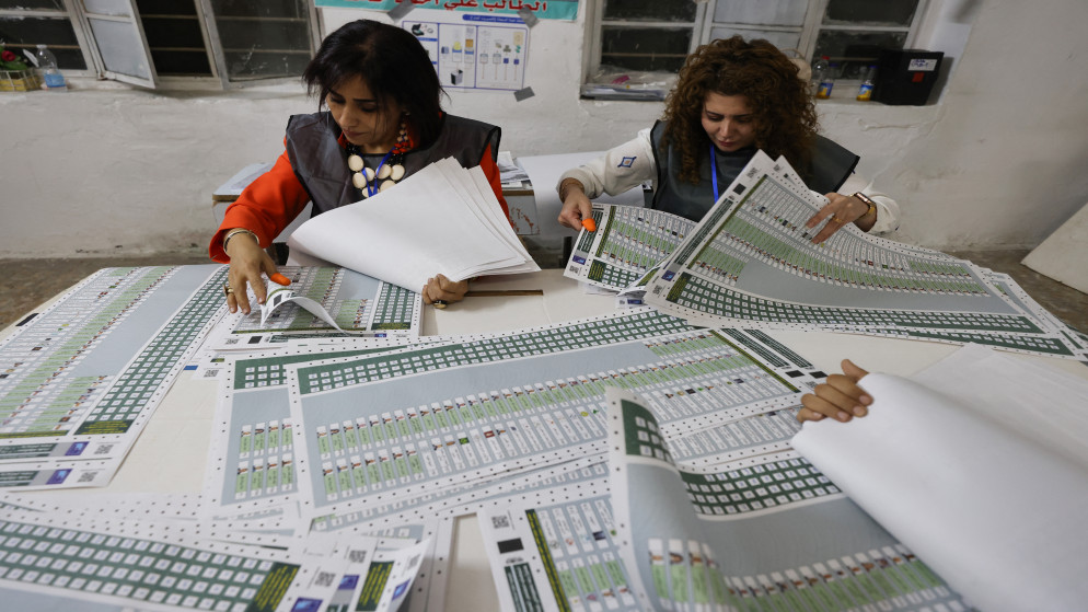 مسؤولو الانتخابات العراقيون يحسبون الأصوات في مركز اقتراع بعد إغلاق الصناديق خلال الانتخابات البرلمانية شرق بغداد، 11 تشرين الثاني 2025. (أ ف ب)