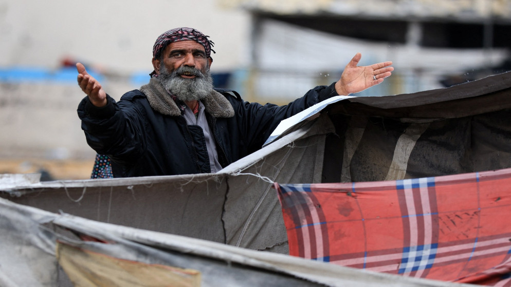 رجل فلسطيني يقف بجانب خيام في يوم ممطر، خلال وقف إطلاق النار بين إسرائيل وحماس، في مدينة غزة، 14 تشرين الثاني 2025. (رويترز)