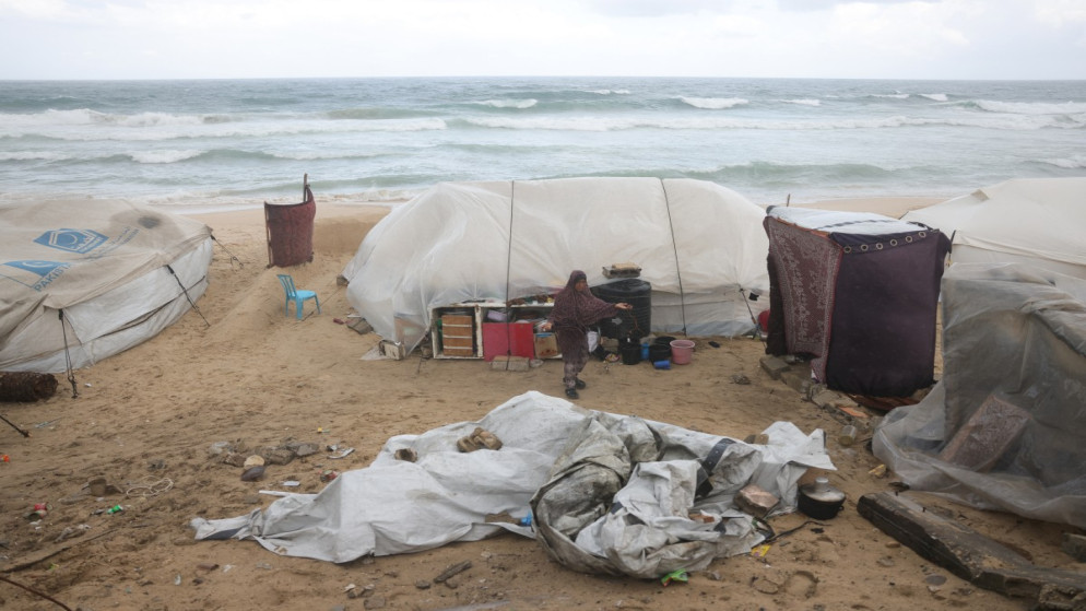 فلسطينية نازحة قرب خيمة غرب مدينة دير البلح وسط قطاع غزة ويظهر تأثير المنخفض الجوي15 تشرين الثاني 2025. (أ ف ب)