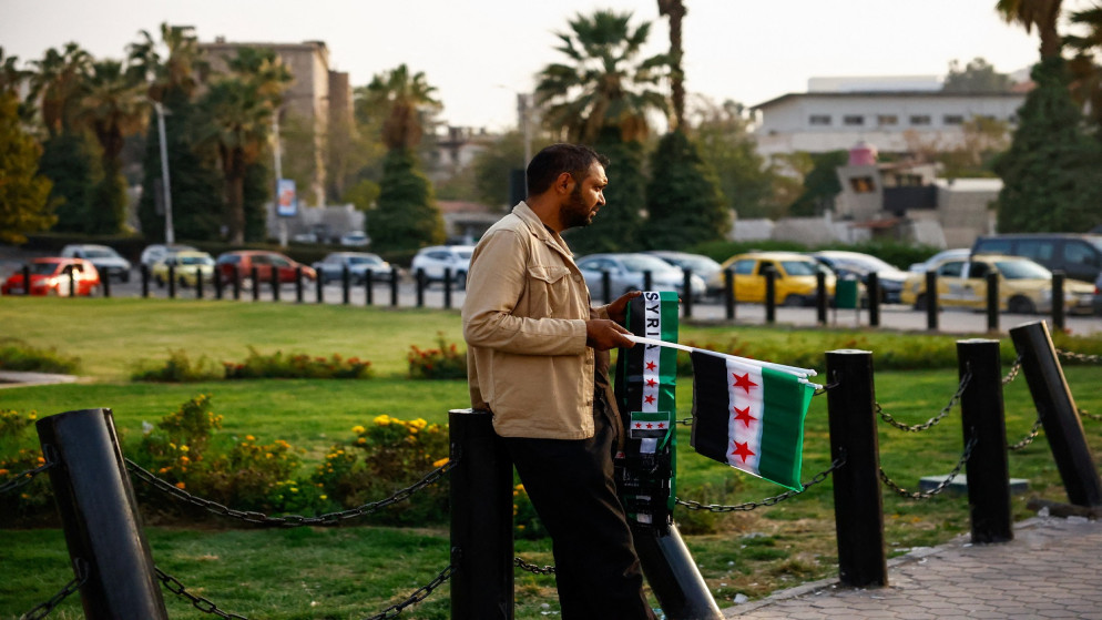 رجل يبيع الأعلام السورية في ساحة الأمويين في دمشق، سوريا، 12 تشرين الثاني 2025. (رويترز)