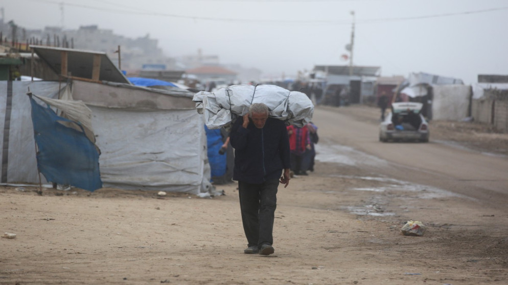 رجل فلسطيني نازح يحمل أمتعته غرب مدينة دير البلح وسط قطاع غزة، 15 تشرين الثاني 2025. (أ ف ب)