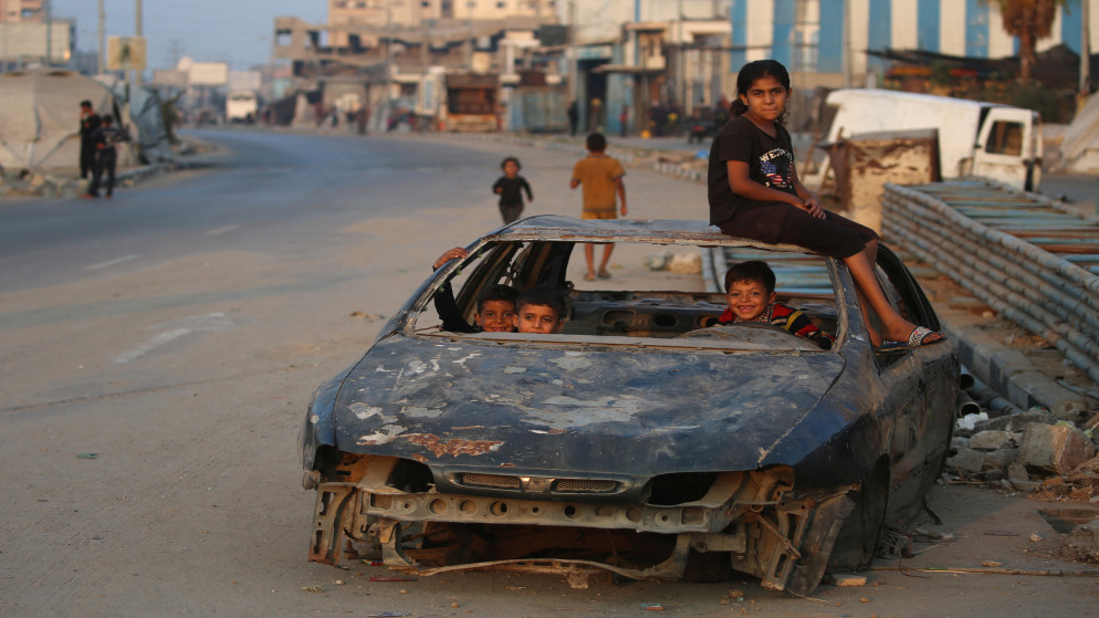 أطفال فلسطينيون يلعبون في سيارة مدمرة في مخيم البريج في وسط قطاع غزة في 10 تشرين الأول 2025. (أ ف ب)