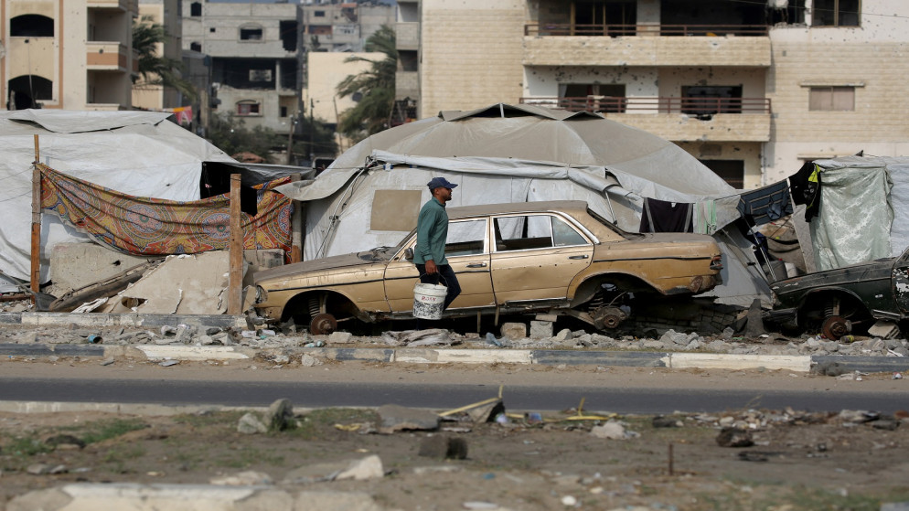 فلسطيني يسير وسط أنقاض المأساة في غزة. (أ ف ب)