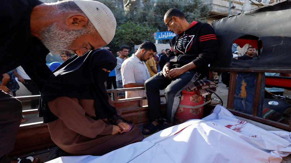 فلسطينيون بجوار جثمان شهيد في مستشفى العودة في وسط قطاع غزة، 20 تشرين الأول 2025. (رويترز)