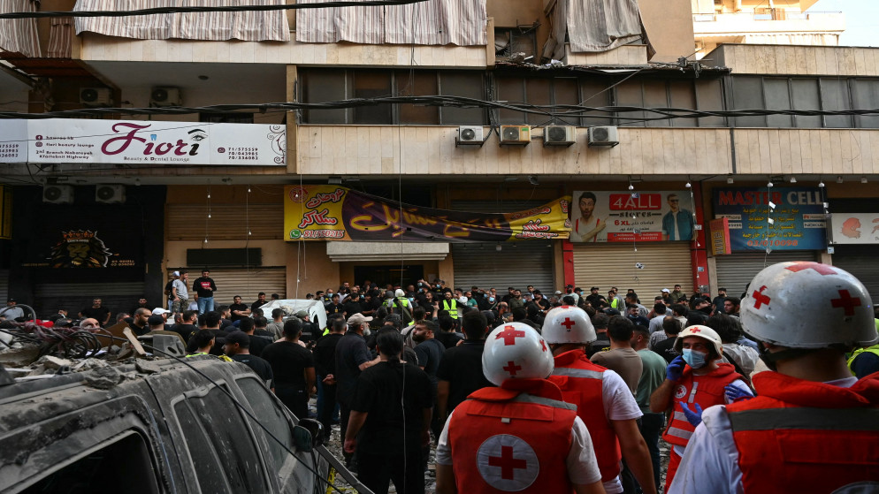 أشخاص يتجمعون وهم ينظرون إلى مبنى سكني بعد غارة عسكرية إسرائيلية في حي حارة حريك بضاحية بيروت الجنوبية، 23 تشرين الثاني/ نوفمبر 2025. (أ ف ب)