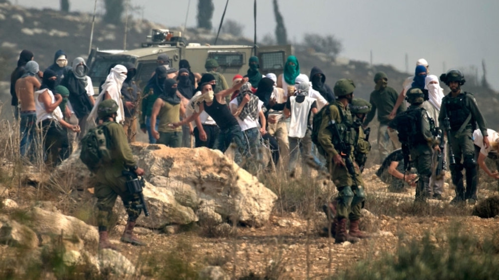 صورة أرشيفية لمستوطنين بحماية جيش الاحتلال الإسرائيلي في الضفة الغربية المحتلة. (وفا)